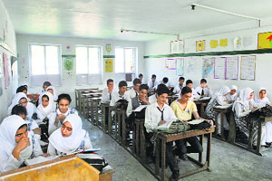 Students of New Convent High School attend classes after the floodwaters recede in Srinagar on Tuesday.