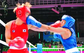 Sarita Devi (R) and South Koreas Park Jina trade punches during the 57-60kg semifinal bout on Monday