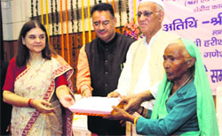 Union Minister Maneka Gandhi distributes provident fund to pensioners in Dehradun on Tuesday.