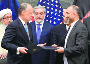 Afghan National Security Adviser Hanif Atmar (R) and US Ambassador to Afghanistan James Cunningham after signing a deal in Kabul on Tuesday