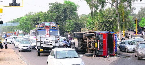 Traffic moves at a snail’s pace as a truck lies overturned at the airport light point on Wednesday. The mishap occurred while the driver was trying to take a U-turn towards Zirakpur. Cranes arrived at the spot, but failed to lift the truck, resulting in the disruption of traffic from 12.30 pm onwards till late in the evening.