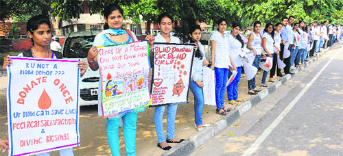 Volunteers form a human chain on National Voluntary Blood Donation Day in Chandigarh on Wednesday.