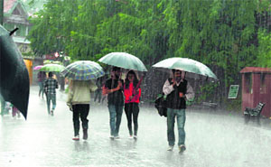 People walk with umbrellas during rain in Shimla on Wednesday.