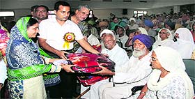 CPS (Woman and Child Development) Nesara Khatoon distributes blankets to senior citizens.