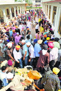 Flood victims line up to receive relief material at Sanat Nagar Gurdwara in Srinagar on Wednesday