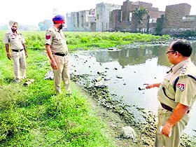 Police officials inspect the spot where the bombs were found in Khanna on Wednesday. 