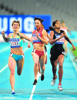Kazakhstans Margarita Mukasheva (L) crosses the finish line ahead of second placed Indias Lukka Tintu (R) in the final of the womens 800m.