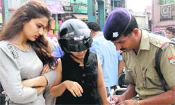 A policeman challans a scooter rider as the girl riding pillion was not wearing a helmet at Clock Tower in Dehradun on Wednesday. Tribune photo: Vinod Pundir