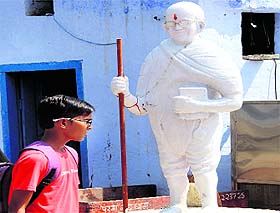 a boy passes by a statue of Mahatma Gandhi in Bathinda on Thursday.