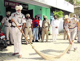 DSP Gurjeet Singh and Kotwali SHO Mahesh Saini hold brooms during the Swachh Bharat Abhiyan