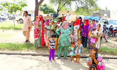 Women watch a candidates campaign at Rupana Jatan village of Ellenabad in Sirsa.