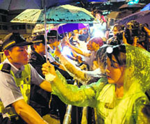 Pro-democracy protesters face policemen as they wait for Hong Kong chief executive. 