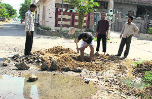 Workers of the Water Supply and Sanitation Department try to locate blockade in a sewer at Model Town, Phase III, in Bathinda on Friday. 