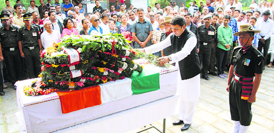 Urban Development Minister Sudhir Sharma pays tribute to Major Abhijay Thapa at his native place Shamnagar in Dharamsala on Friday. Photo: Kamaljeet 