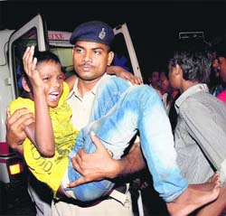 A policeman takes a victim to a hospital in Patna on Friday