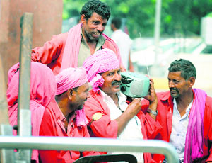Coolies listen to Prime Minister Narendra Modis speech on radio on the occasion of Dasehra at the Ludhiana railway station on Friday.