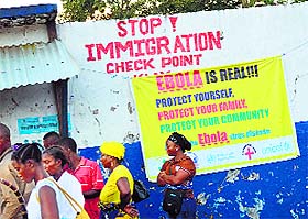 People waiting to be screened against the Ebola virus at a border crossing with Sierra Leone in Liberia's Cape Mount province. 