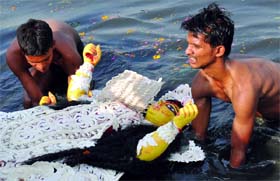 Devotees immerse an idol of Goddess Durga into the Yamuna in New Delhi on Saturday.