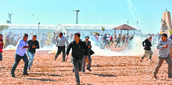 Kurdish protestors run away from tear gas during their clash with Turkish soldiers near the Mursitpinar border crossing on the Turkish-Syrian border in Suruc on Saturday. AFP