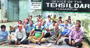 Members of the Patwari and Kanungo Association protest in front of the Tehsildar Office in Hamirpur on Thursday.