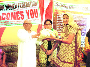 Former Vice-Chairman of the Agro Packaging Corporation Omkar Sharma distributes seed kits to members of the Swan Women Federation in Una on Saturday.