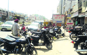 Vehicles parked haphazardly on the Tehsil Road in Jagraon.
