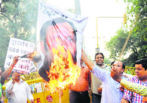 Congress workers burn an effigy of I&B Minister Prakash Javdekar during a protest against Doordarshan for live telecast of RSS Dasehra rally, in Delhi on Sunday.