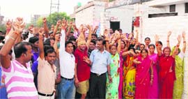 Residents of Rejesh Nagar and migrants agitate outside Mohkampura police station in Amritsar on Monday.