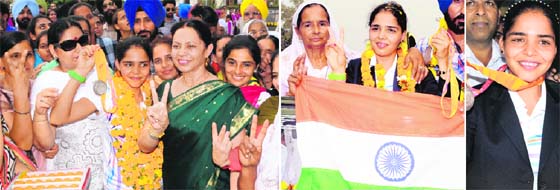 The first Indian silver medallist in the 21-km race walk in the Asian Games, Khushbir Kaur is greeted by the Principal and staff of Khalsa College for Women upon arriving in Amritsar from South Korea on Monday; and (right) Khushbir Kaur and her mother show the victory sign at railway station.