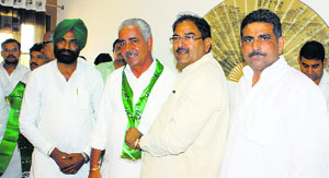 Abhay Singh Chautala offers INLD scarf to Fatehabad BJP president Molu Ram Rulania after the latter joined the party in Fatehabad on Monday.