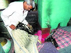 Parkash Chand, the house owner, shows the burnt household articles in Nurpur on Monday. 