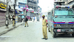 Policemen stand guard at a street in the Lal Chowk area of Srinagar. Tribune Photo: Yawar Kabli