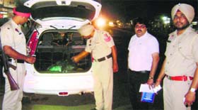 Police officials check a vehicle during a naka at the Sahnewal chowk in Dehlon on Monday.