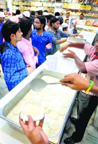 Muslims relish sweets on Eid-ul-Zuha in Ludhiana on Monday.