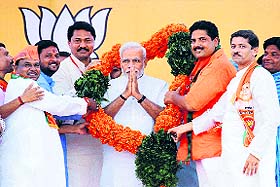 Prime Minister Narendra Modi is grreted with a garland by BJP candidates at an election rally in Gondia on Sunday.