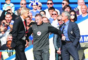 Arsenal manager Arsene Wenger and Chelsea manager Jose Mourinho are kept apart by the fourth official on Sunday