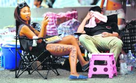 Protester sit under a tent as they help to block an area around the government headquarters in Hong Kong on Monday.