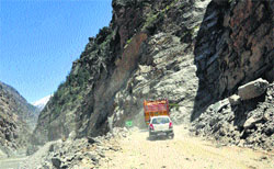 Vehicles cross on a damaged road in Kinnaur district on Tuesday. Photo: Amit Kanwar