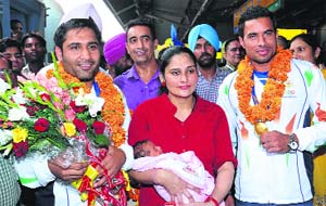 Gurpreet Singh (left), the ace kabaddi player along with his wife and child, and Gurbaz Singh, a member of the Indian hockey team, when they returned home on Tuesday after winning the gold medal at the Asian Games held at Incheon, South Korea