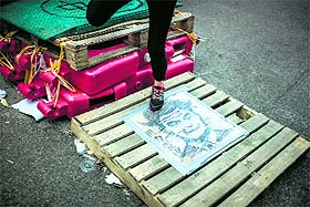 A woman steps on a portrait of Hong Kong chief executive Leung Chun-ying depicted as a vampire on a road blocked by barricades in Hong Kong.
