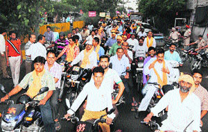 Migrants and activists of Hindu organisations take out a march in Amritsar on Friday to protest police inaction against the culprits involved in thrashing a woman in Mohkampura area. 