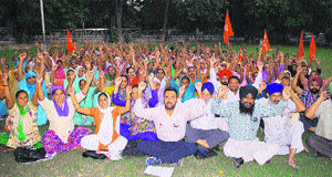 Mid-day meal workers stage a protest at Company Bagh in Amritsar on Wednesday.