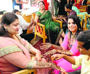 Women apply mehandi for Karva Chauth in Chandigarh. 