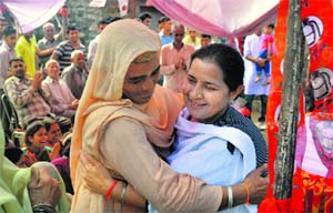 HJC-HJCP candidate Shakti Rani Sharma hugs a woman during a campaign in the Morni area on Wednesday