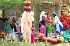 Far from development: Women fetch water from a handpump in Mewat on Wednesday