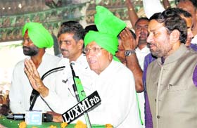 Om Prakash Chautala addresses a rally to seek votes for Balwan Singh Daulatpuria and Ravinder Baliyala (both standing on Chautala's right) in Fatehabad on Wednesday