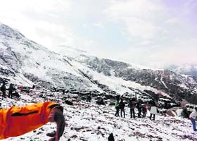 Tourists enjoy fresh snowfall at Rohtag Pass in Manali on Wednesday