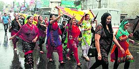 Computer teachers hold a protest march in heavy rain in Jalandhar on Wednesday.