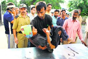 A child injured in cross-border firing being brought to a hospital in Jammu on Wednesday