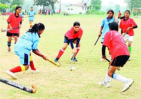 Girls vie to take control of the ball in a match in the state-level Students Hockey Championship at the Sports Stadium in Dehradun on Wednesday. 